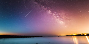 rainbow sky with shooting star over beach