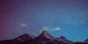 purple and blue galaxy over 3 mountains