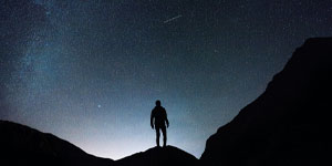 man standing and looking at galaxy
